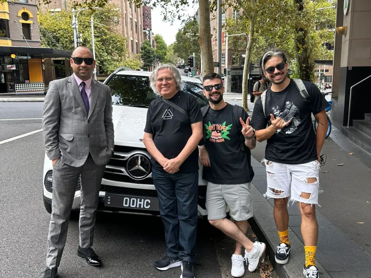 Harmony Rides chauffeur welcoming clients beside a Mercedes