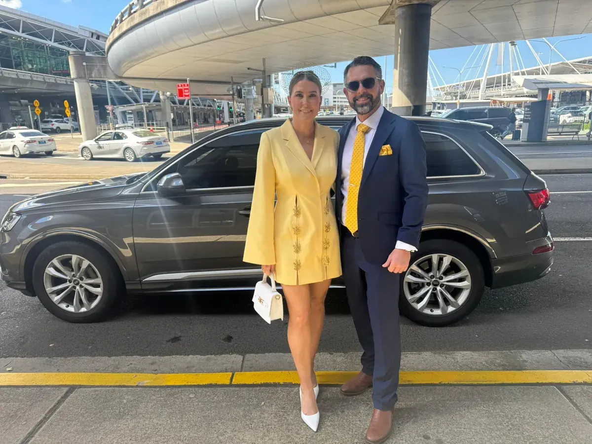 Harmony Rides clients beside a premium Audi at Sydney Airport