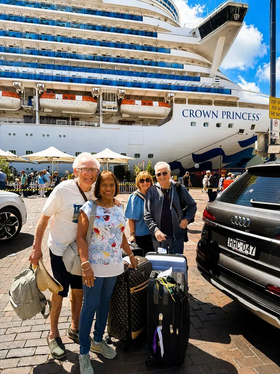 Cruise terminal passengers with luggage beside their Harmony Rides vehicle